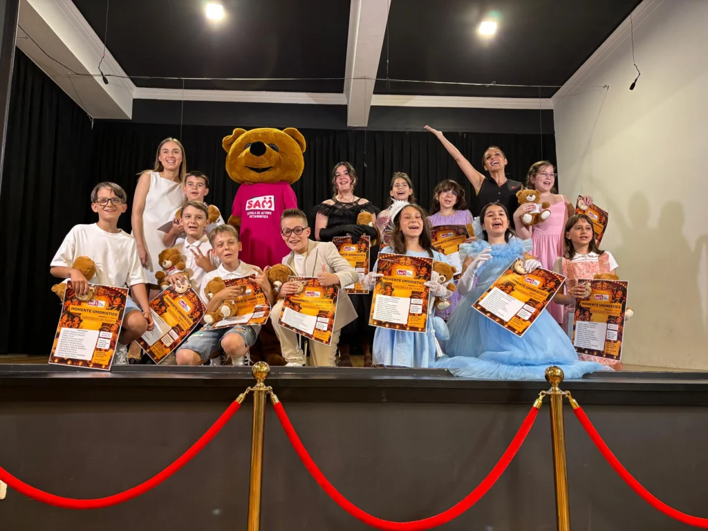 Copii cu diplome portocalii, lângă mascota urs