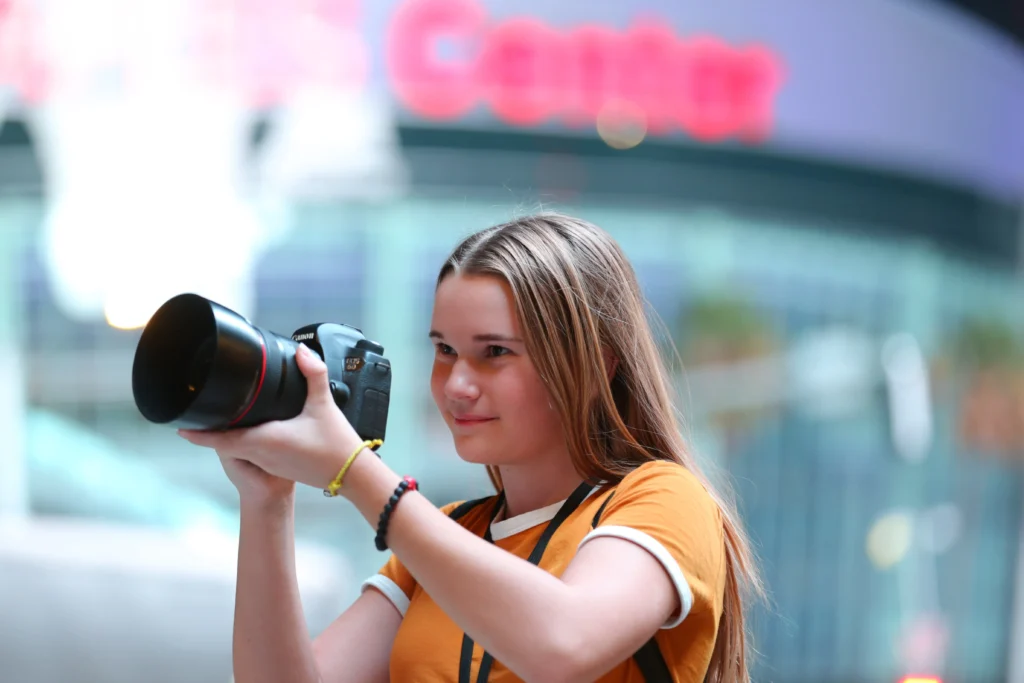 Adolescentă care fotografiază cu un aparat foto